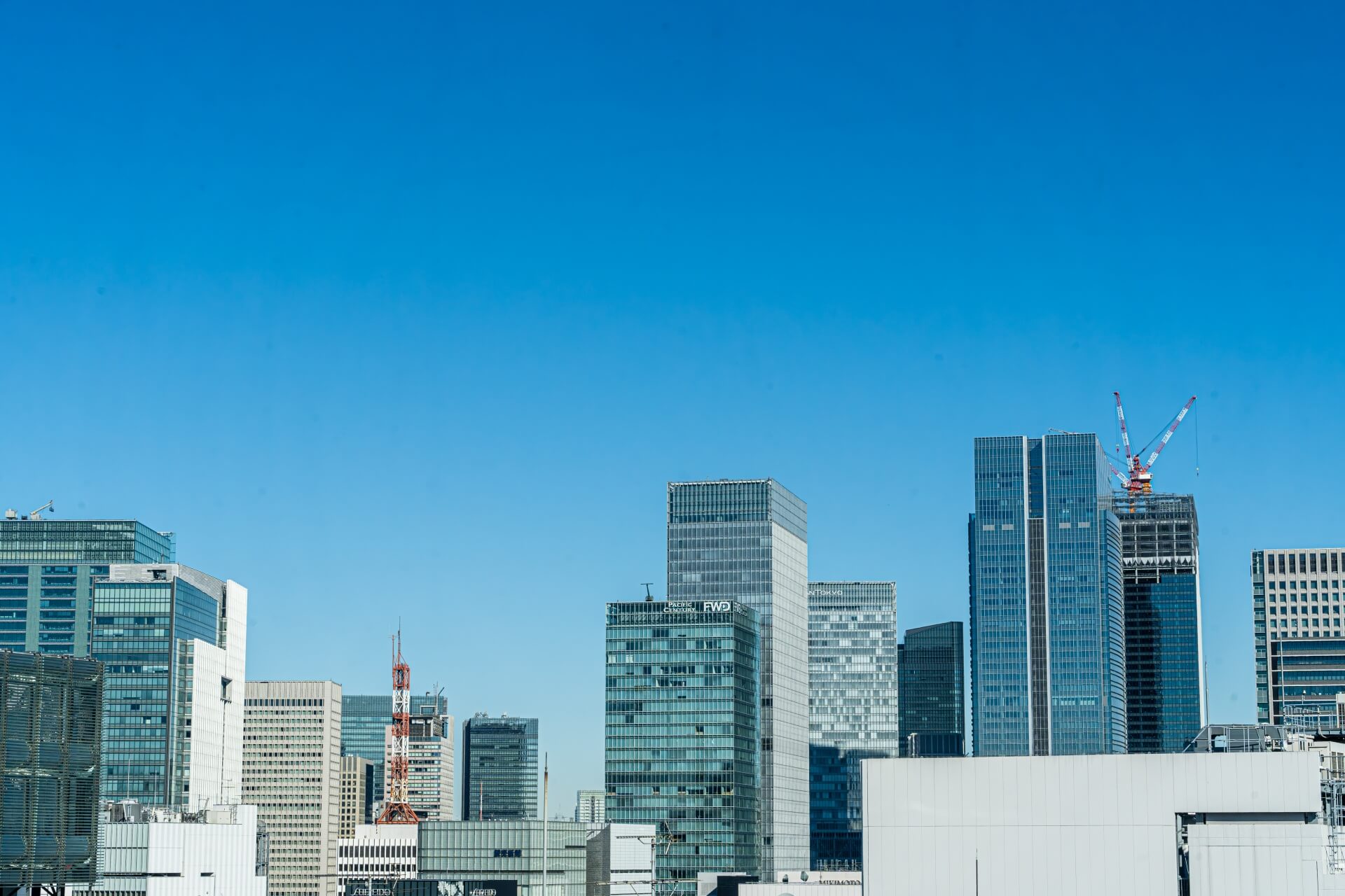 複数の会社ビルと青空が広がる風景。